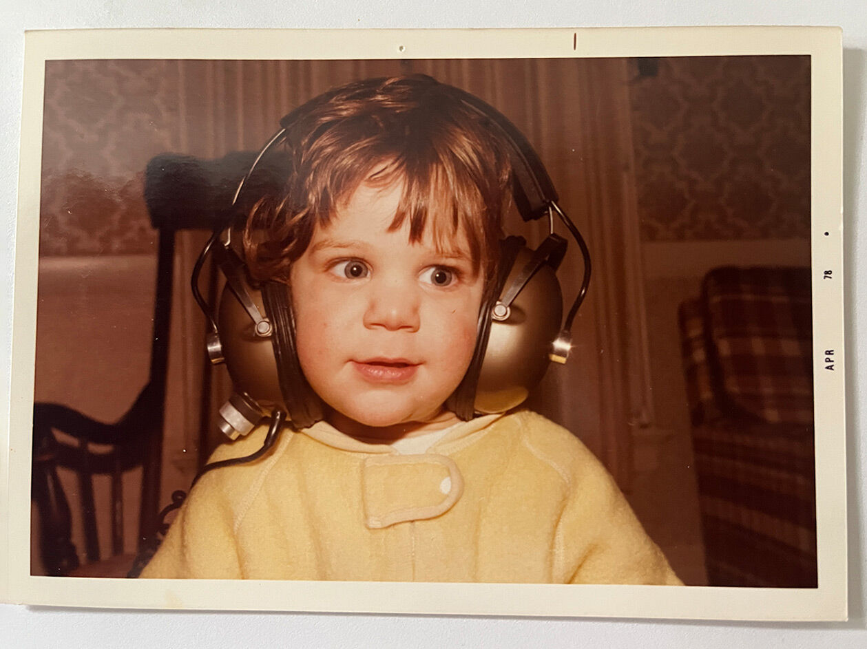A young Matthew wearing headphones